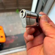 Locksmith holding a euro cylinder lock with key during a call-out