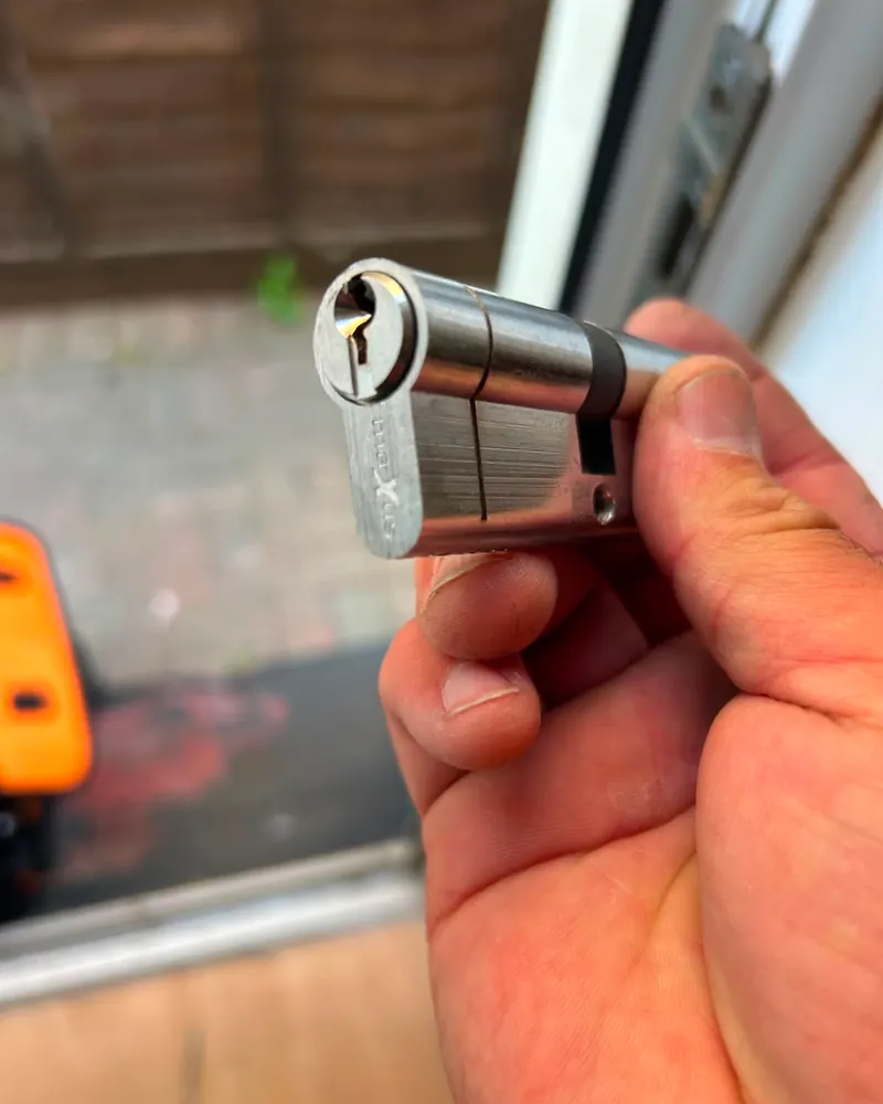 Locksmith holding a euro cylinder lock with key during a call-out