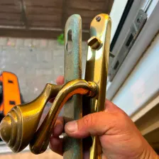 Old worn brass door handle backplates removed from a door