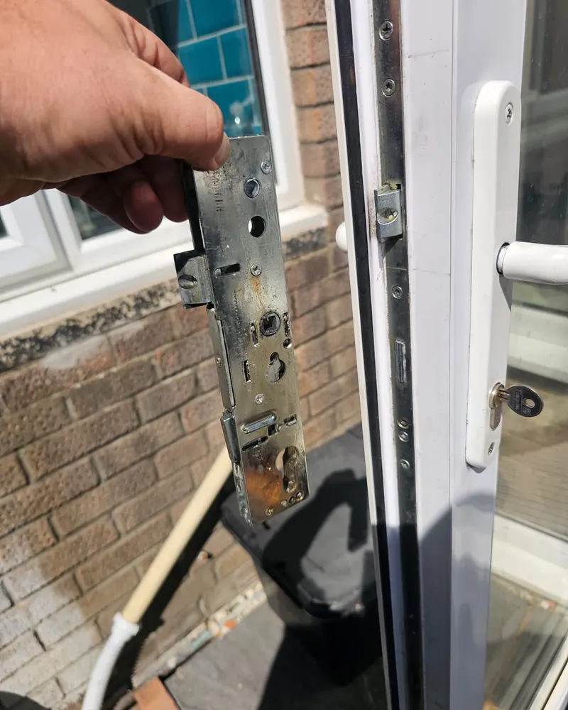 Rusty corroded multi-point lock mechanism held next to a door