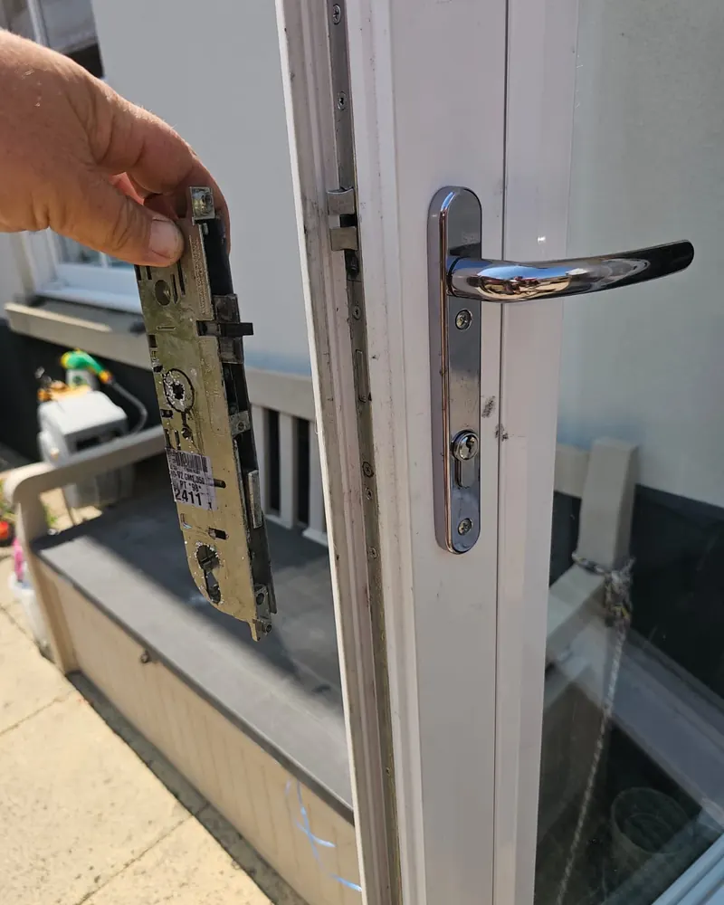 Old multi-point lock mechanism removed next to a uPVC French door