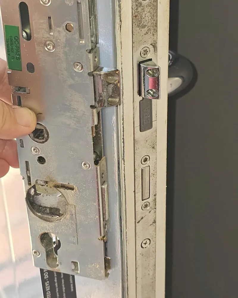 Close-up of a worn, corroded multi-point lock mechanism